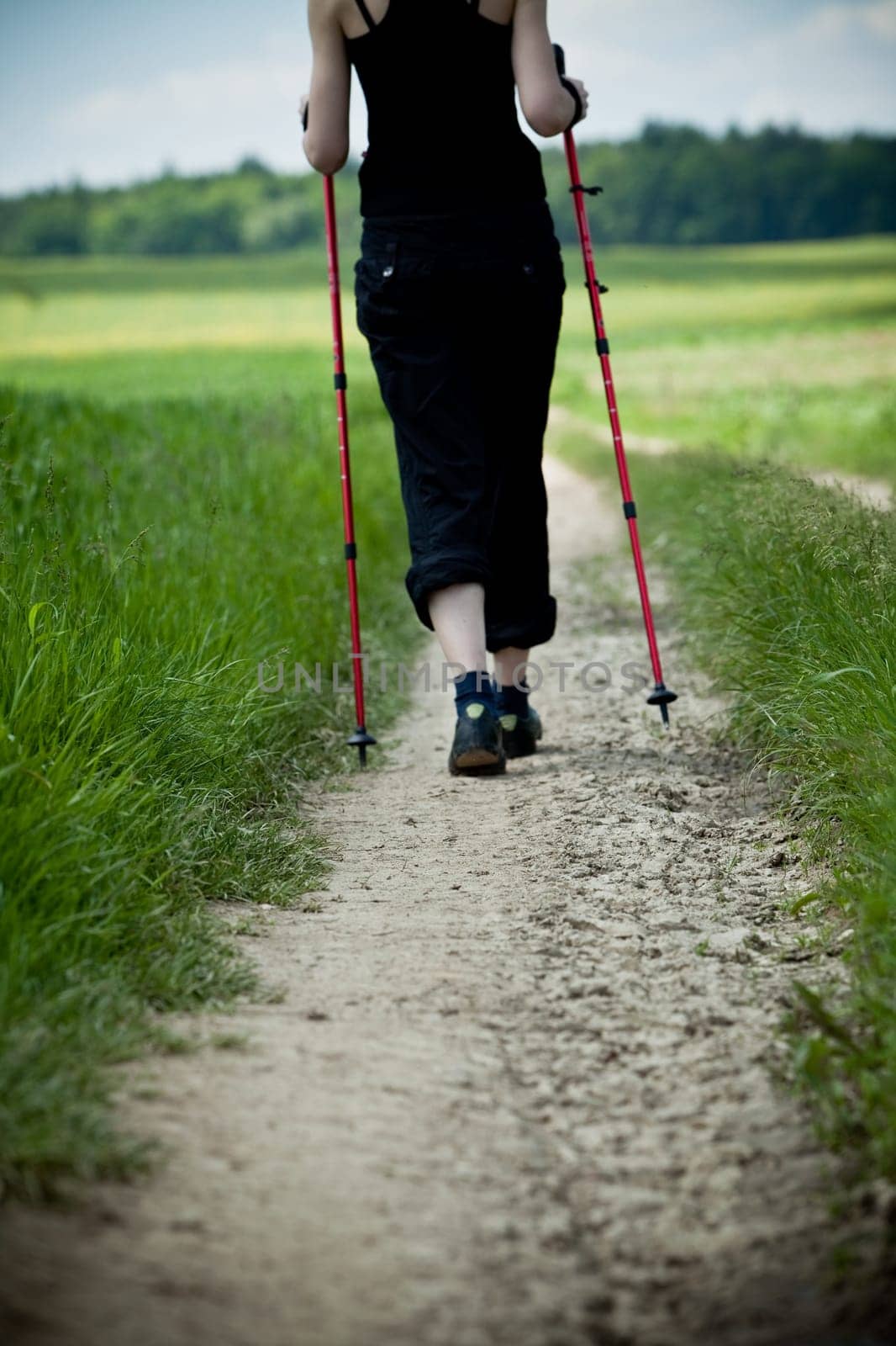 Nordic Walking - young woman is hiking