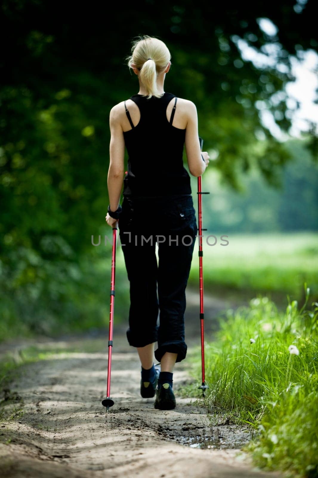 Nordic Walking - young woman is hiking