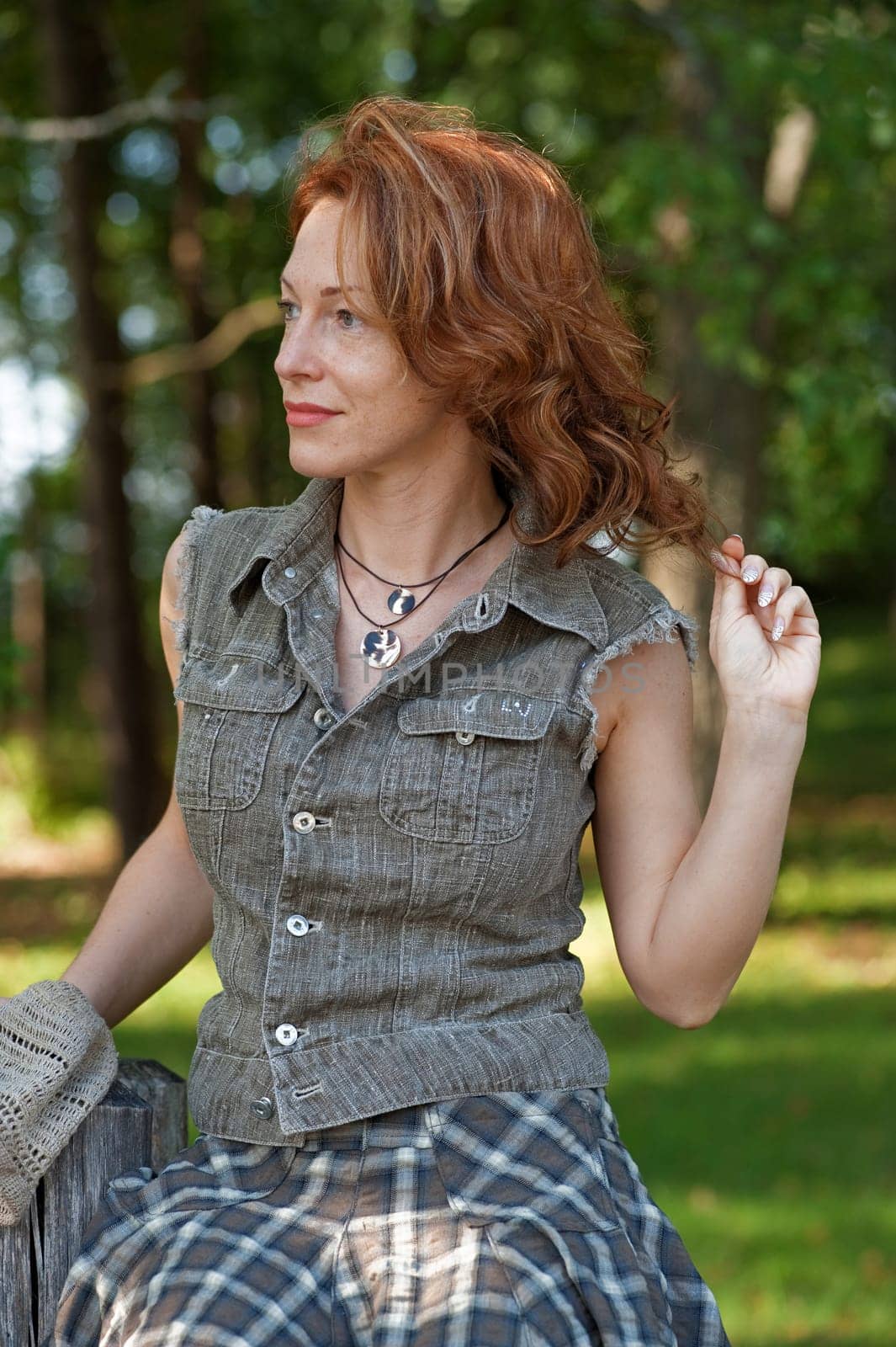 Red-haired adult women in meadow near th