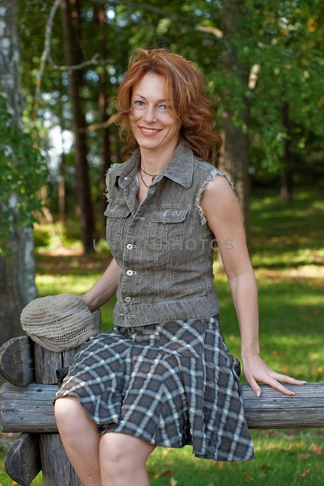 Red-haired adult women in meadow near th