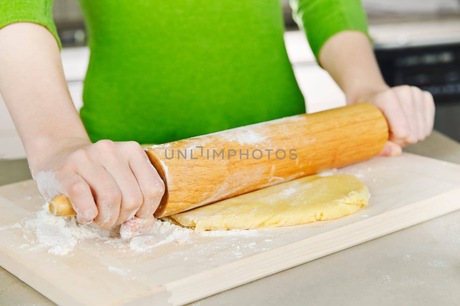 Hands with rolling pin and cookie dough