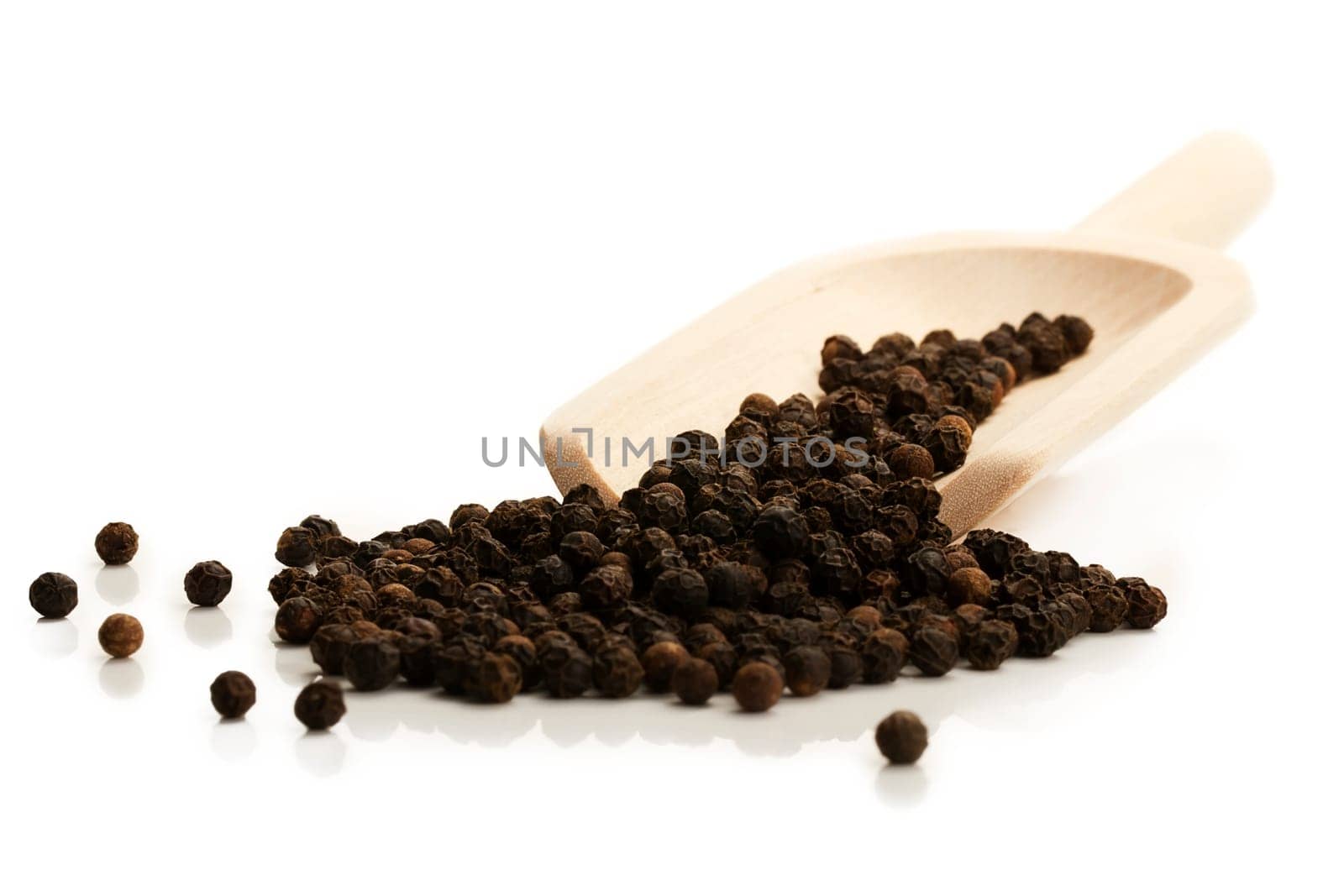 Black peppercorns with wooden shovel