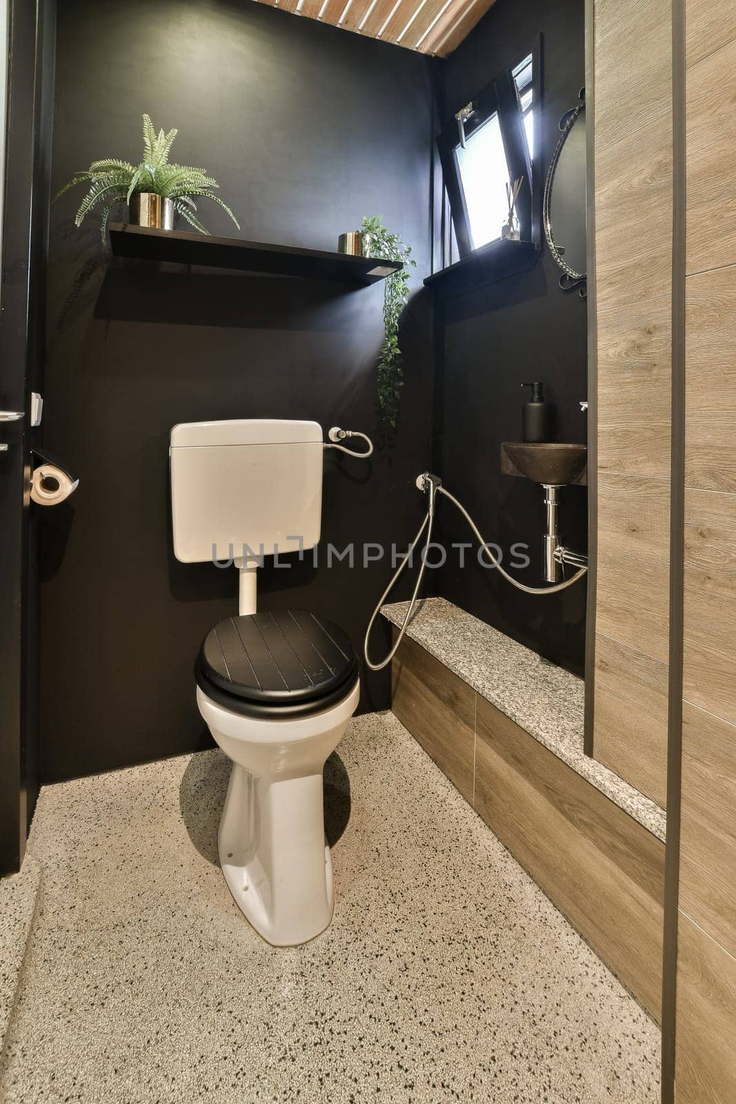 a bathroom with a white toilet and a black wall by casamedia