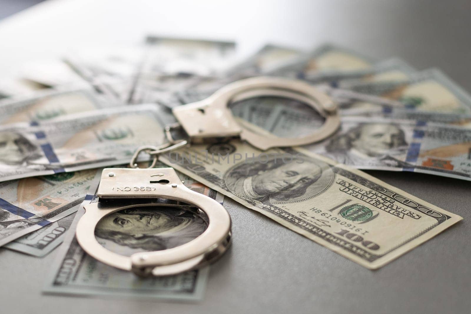 Handcuffs Laying on Newly Designed U.S. One Hundred Dollar Bills. High quality photo