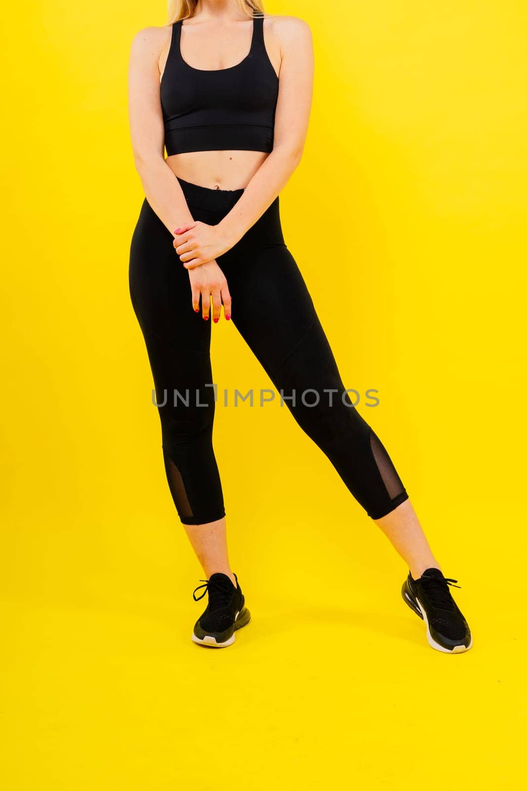 Beautiful young woman dressed in sports uniform, posing in the studio. Healthy lifestyle, sport