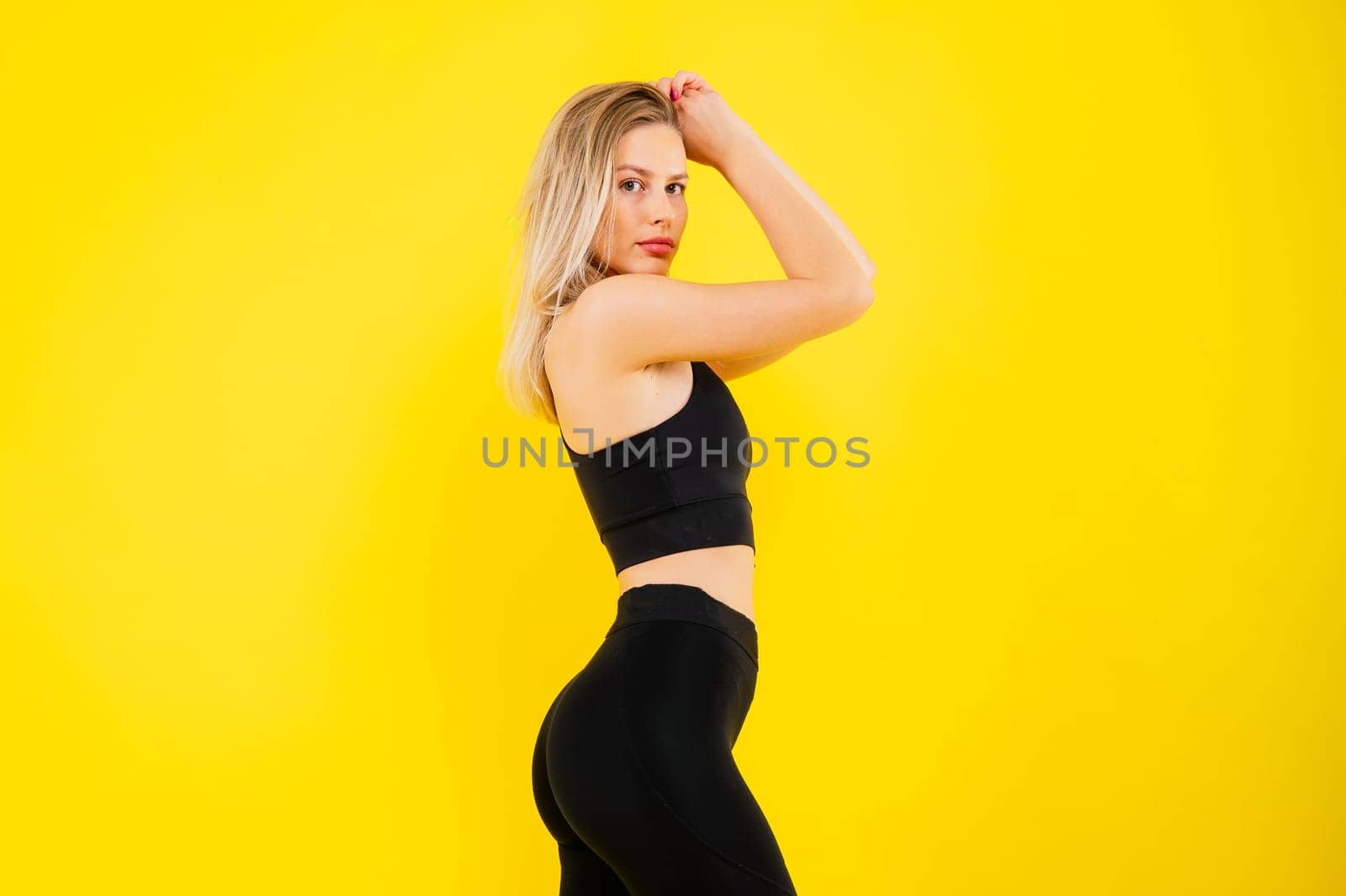 Beautiful young woman dressed in sports uniform, posing in the studio. Healthy lifestyle, sport