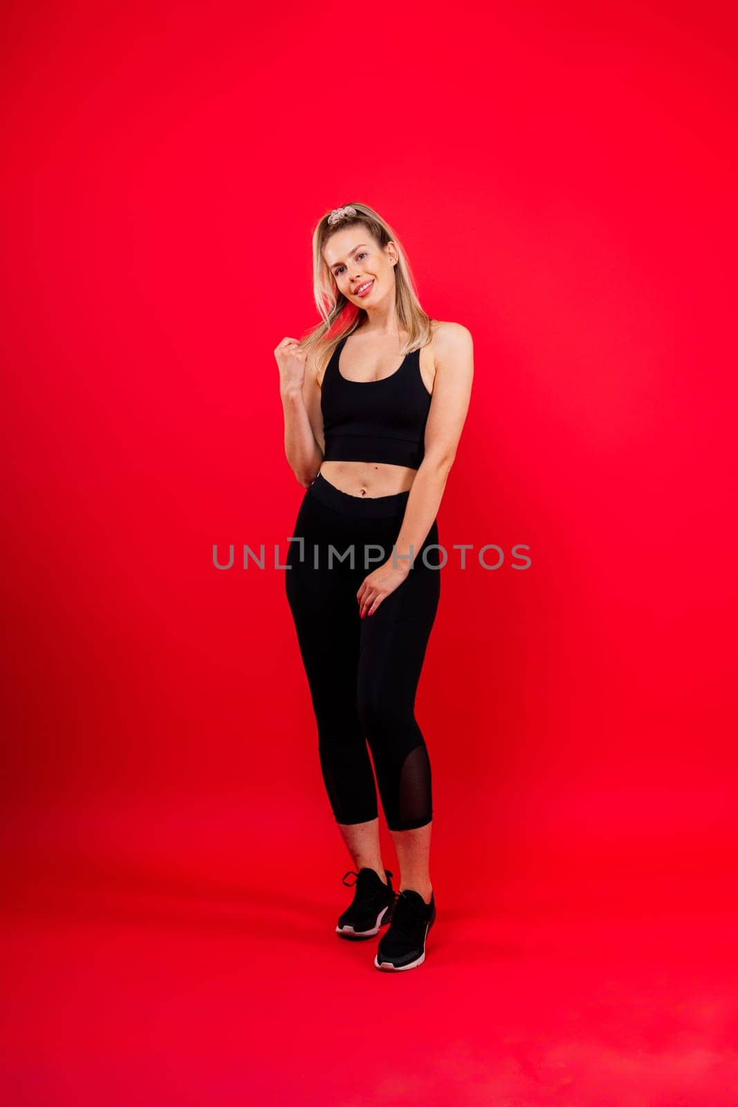 Beautiful young woman dressed in sports uniform, posing in the studio. Healthy lifestyle, sport