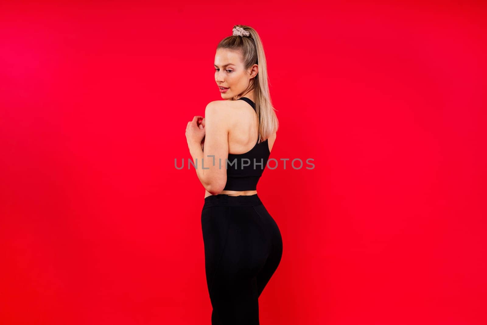 Beautiful young woman dressed in sports uniform, posing in the studio. Healthy lifestyle, sport