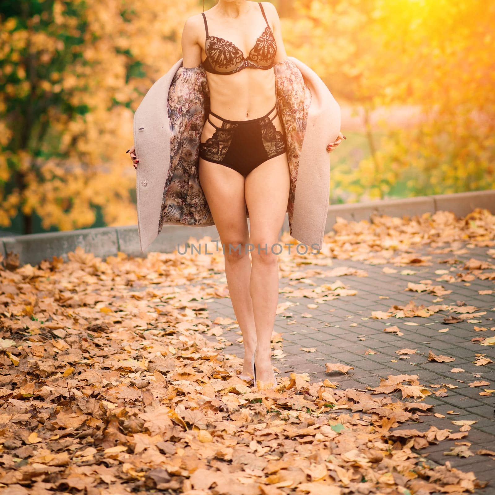 Fashion image of perfect long slim woman legs in an autumn park.