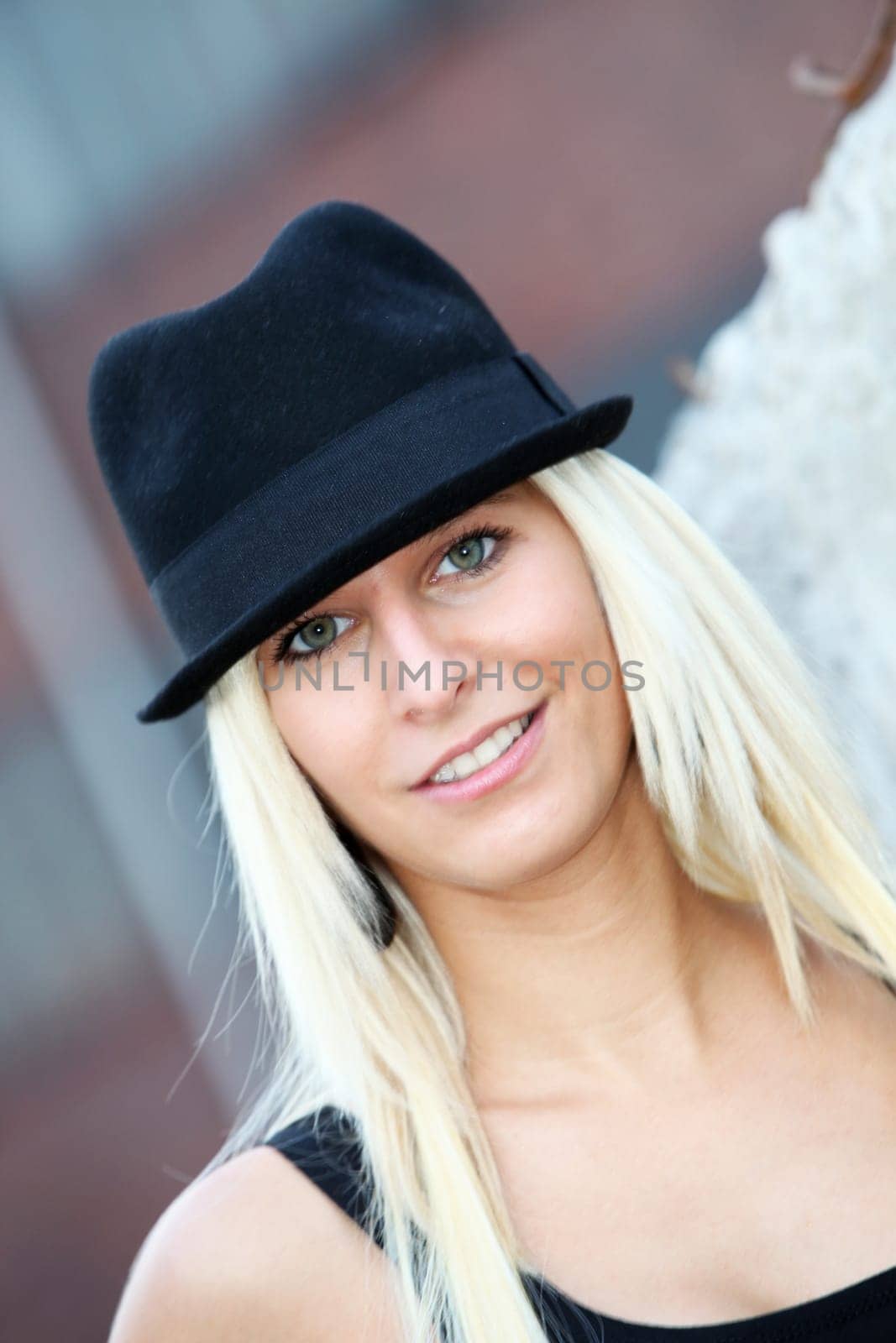 young, smiling blond woman with hat