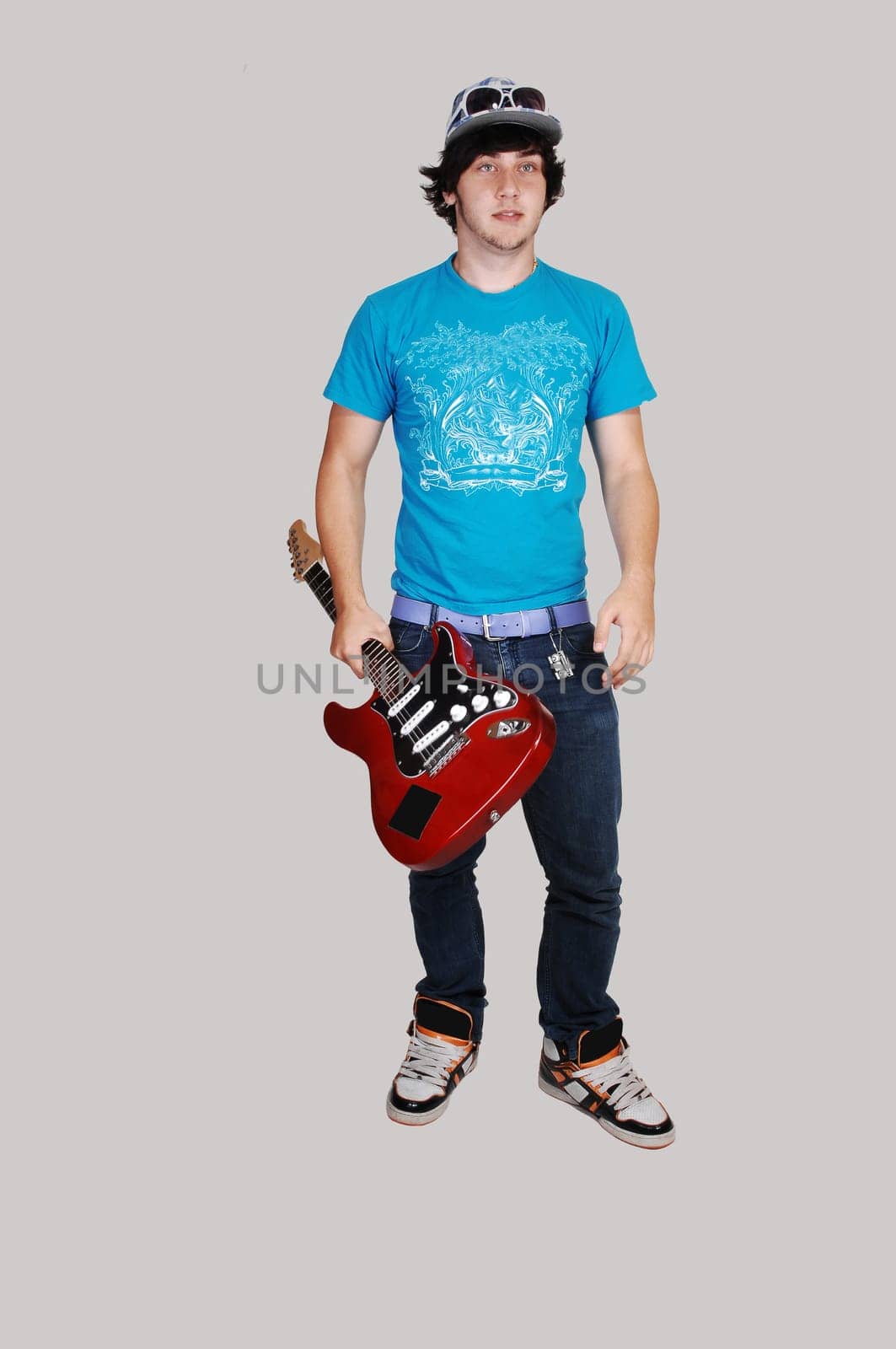 Boy standing with guitar.