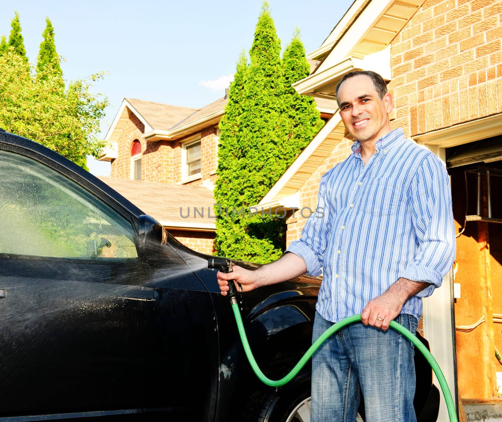 Man washing car on driveway