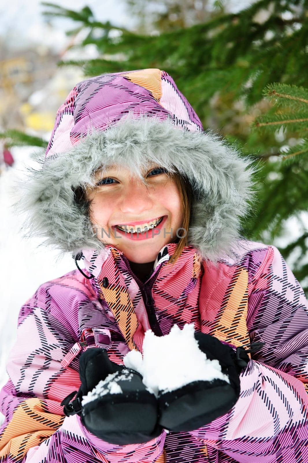 Happy winter girl holding snow