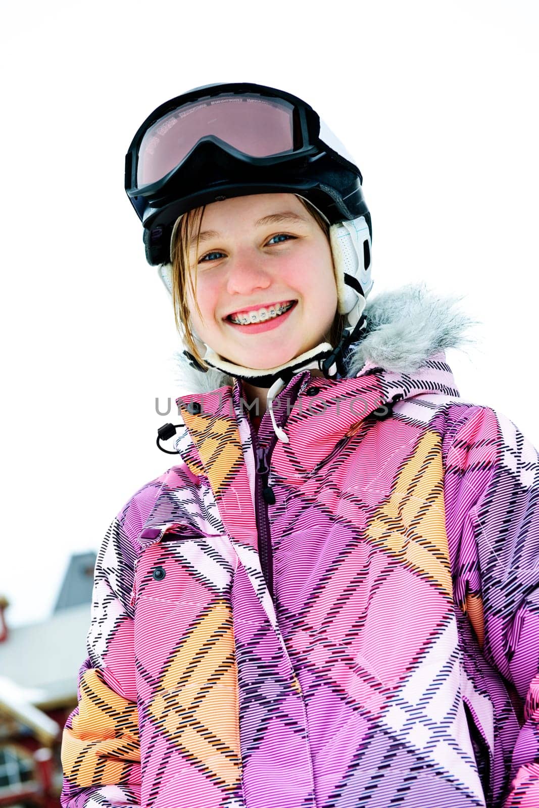 Happy girl in ski helmet at winter resort