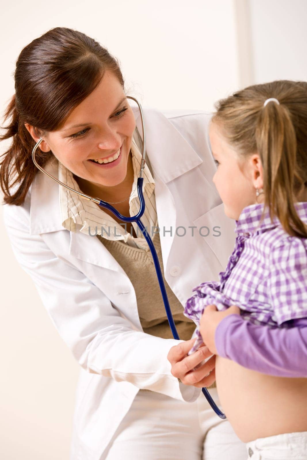 Female doctor examining child with stethoscope