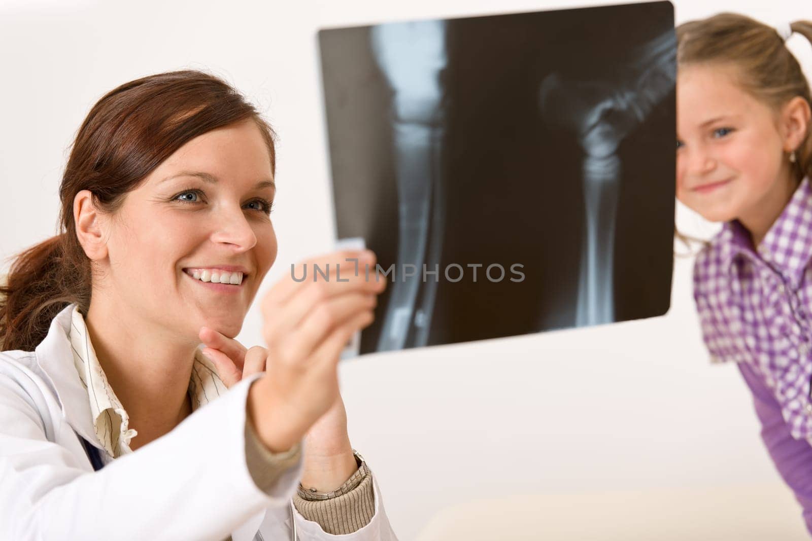 Young female doctor show x-ray to child