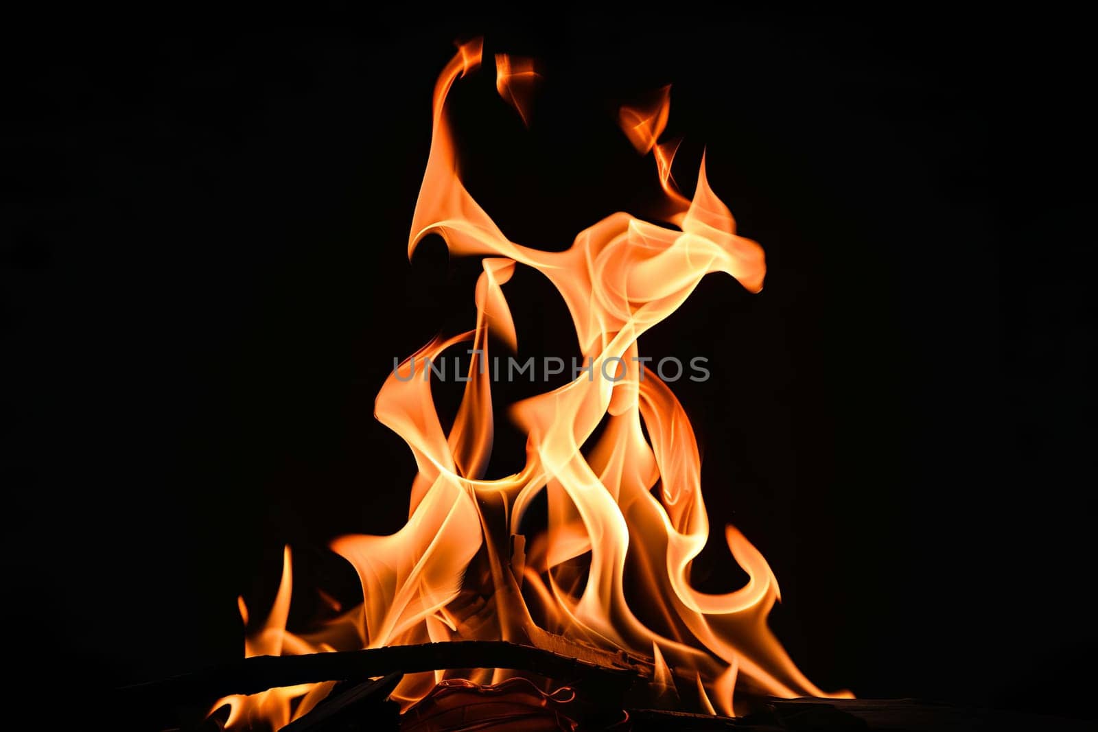 Vibrant orange flames against dark black background.