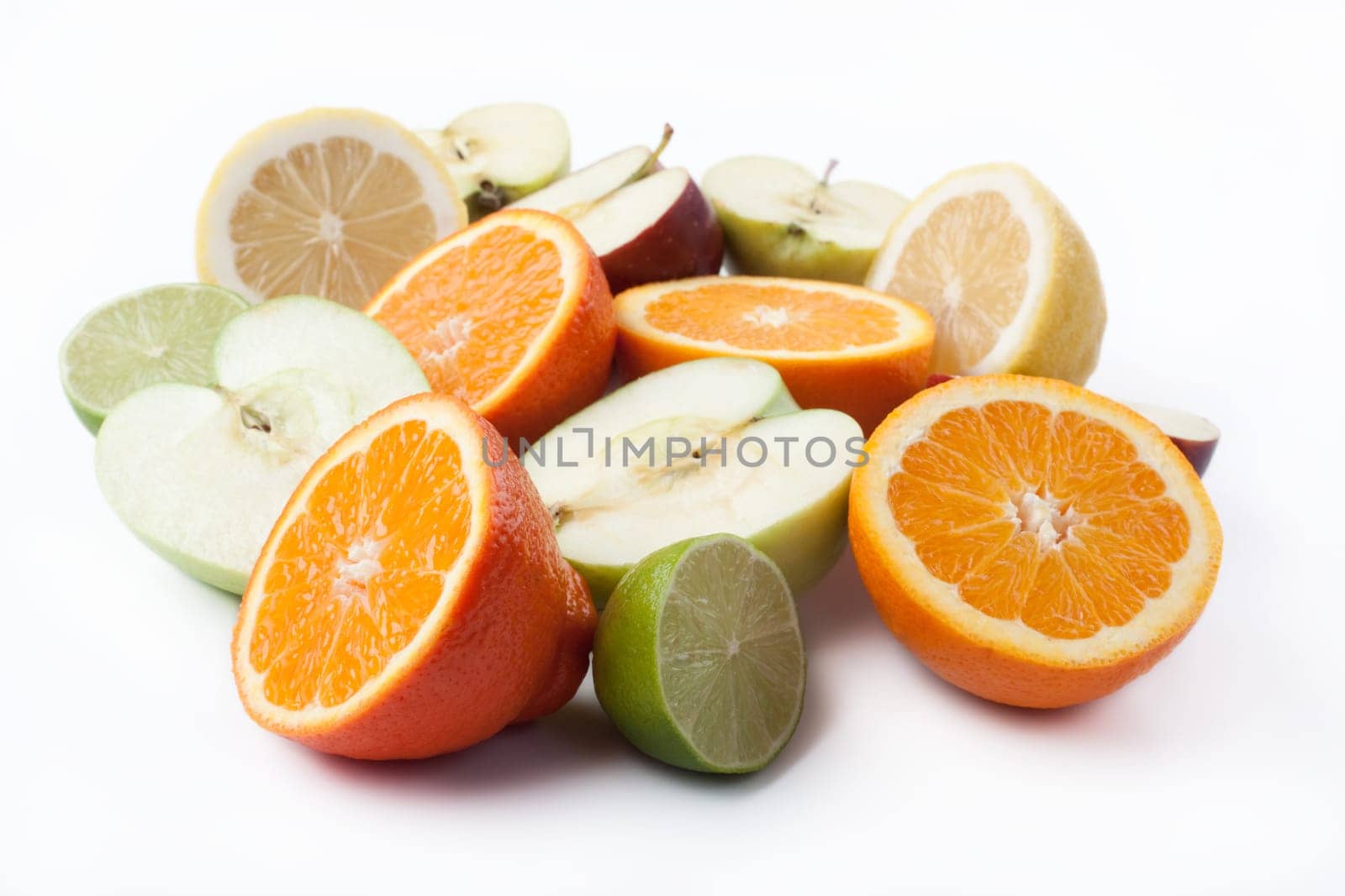 Group of cut citrus and apples on white