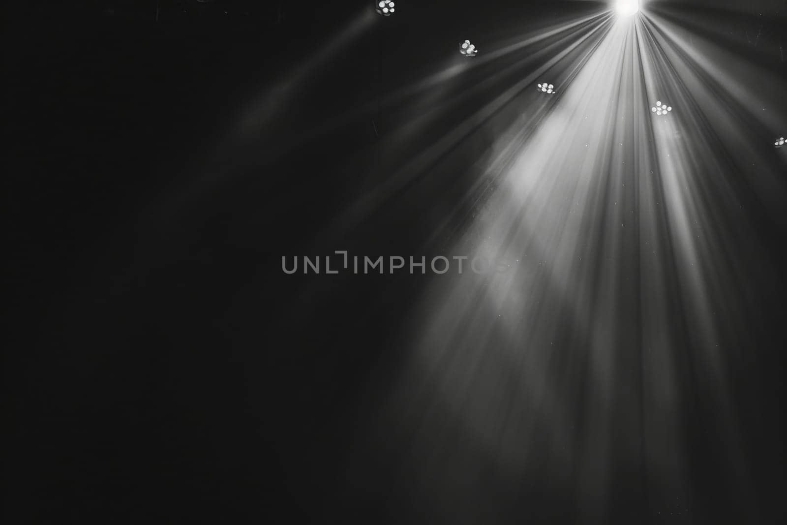 Bright spotlight rays shining in dark theater stage environment.