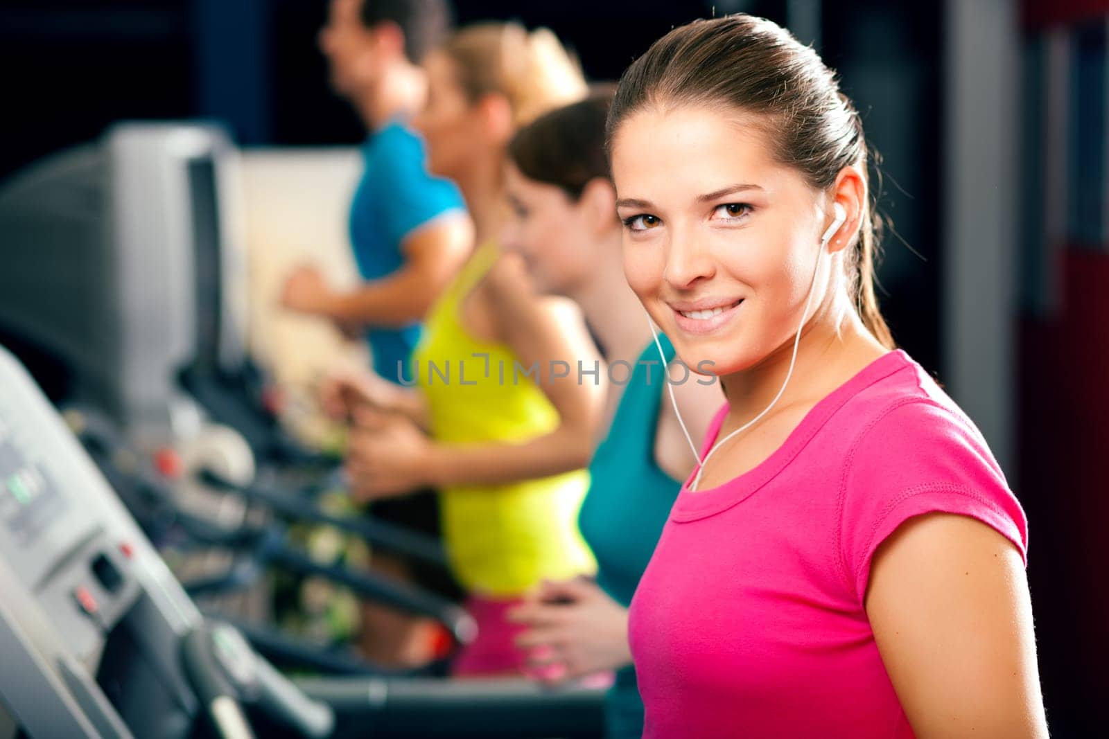 People running on treadmill in fitness stud