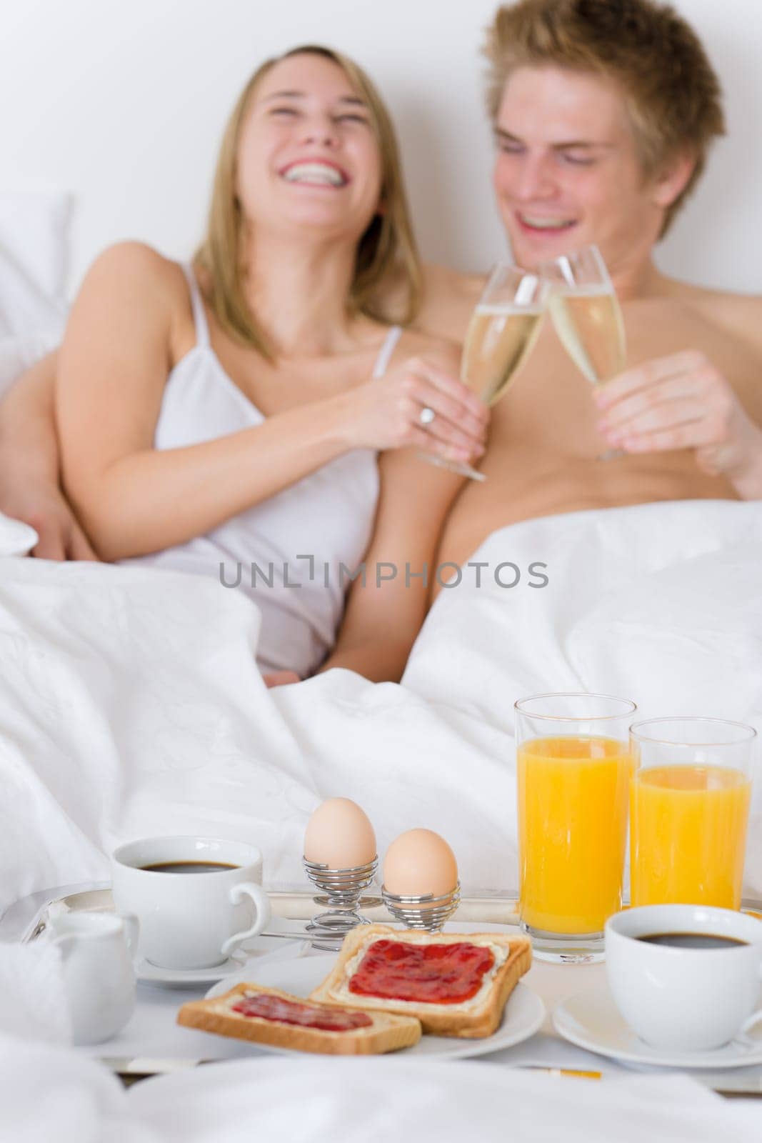 Luxury hotel honeymoon breakfast - couple in bed