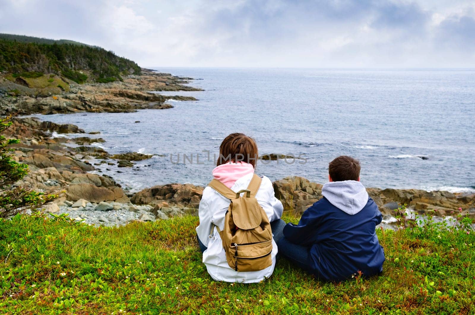 Children sitting at Atlantic coast in Newfoundland
