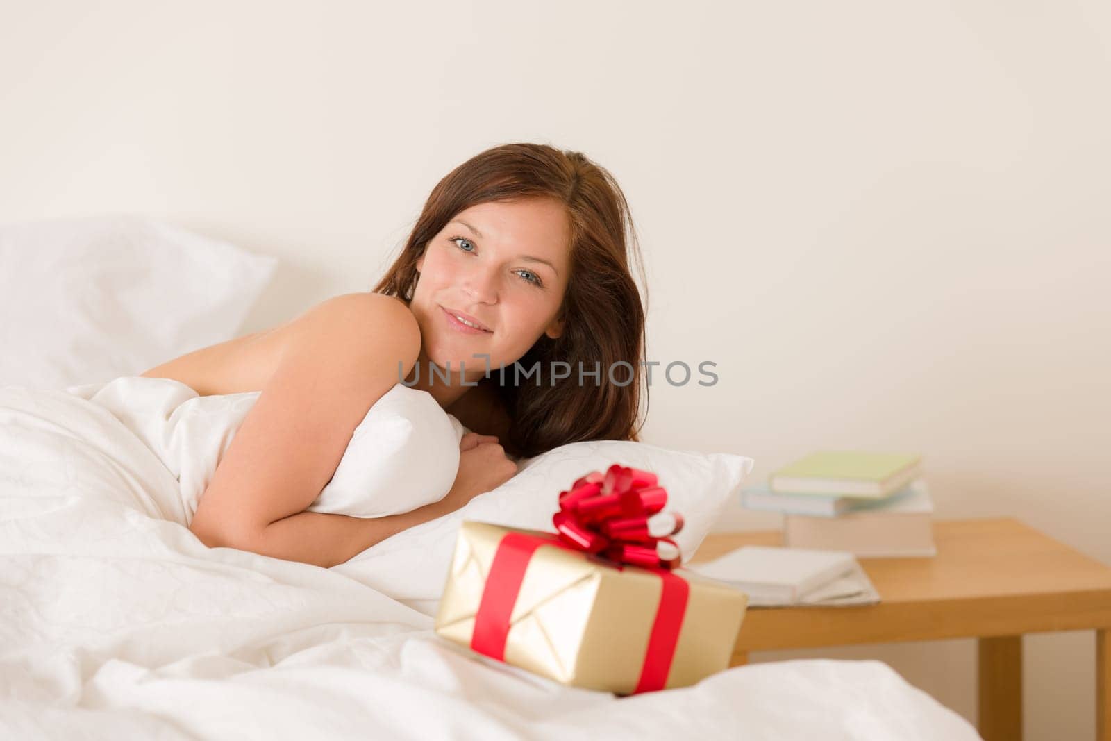 Bedroom surprise present - young happy woman