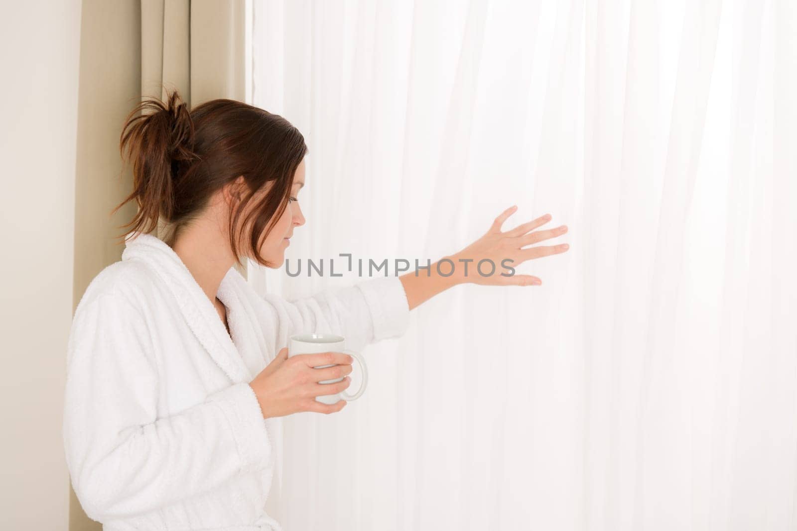 Morning bedroom - woman in bathrobe with coffee