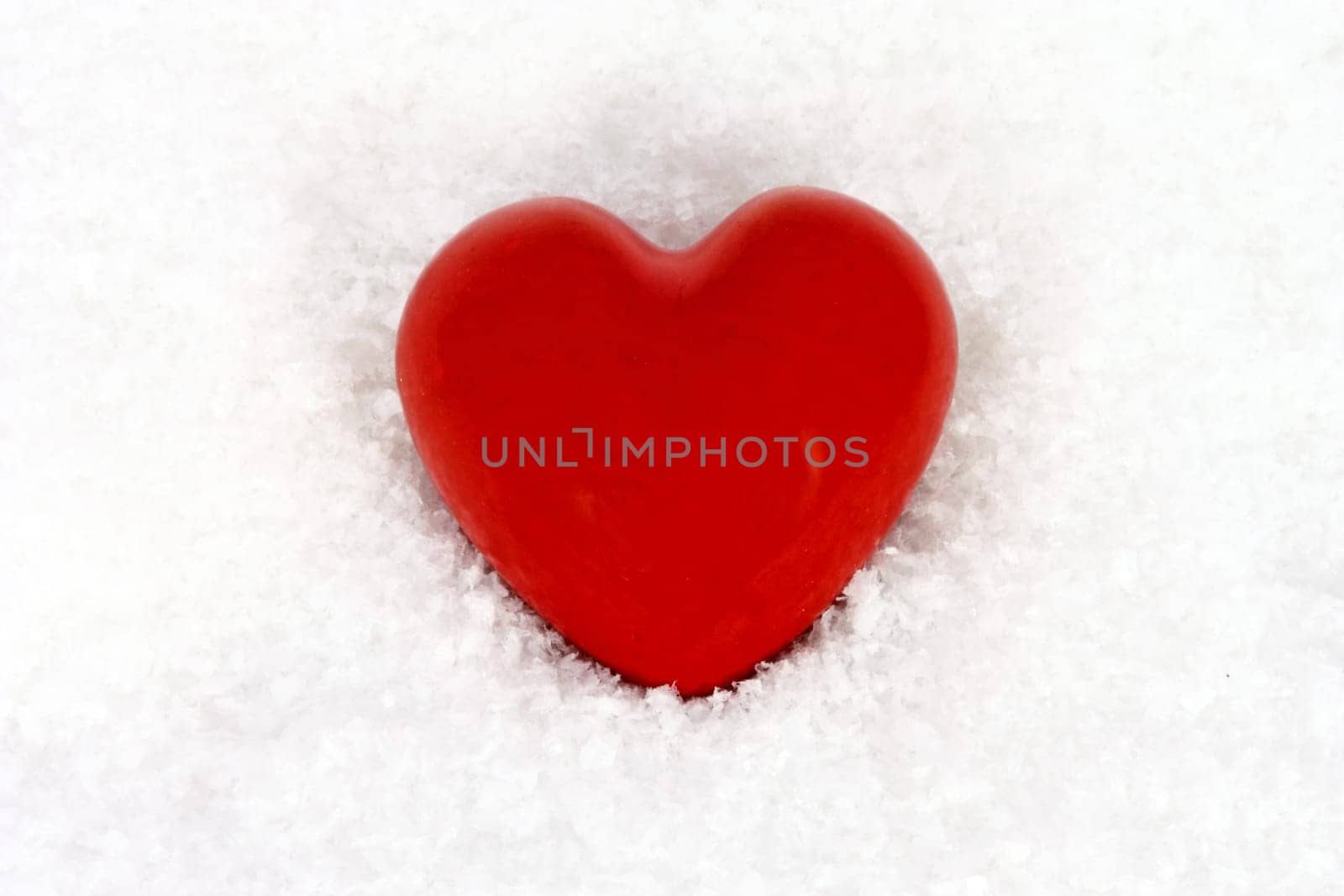 Red stone heart in artificial snow