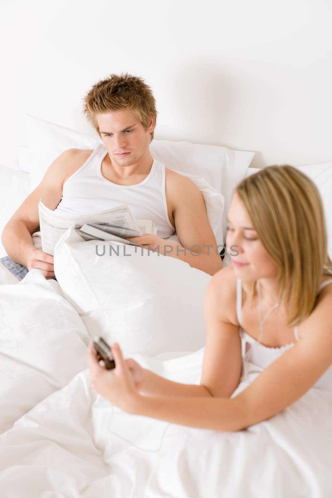 Young couple relax in bed listen to music