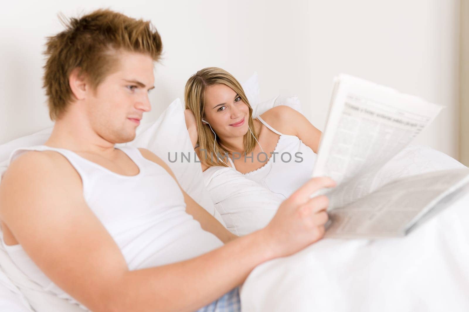 Young couple relax in bed listen to music