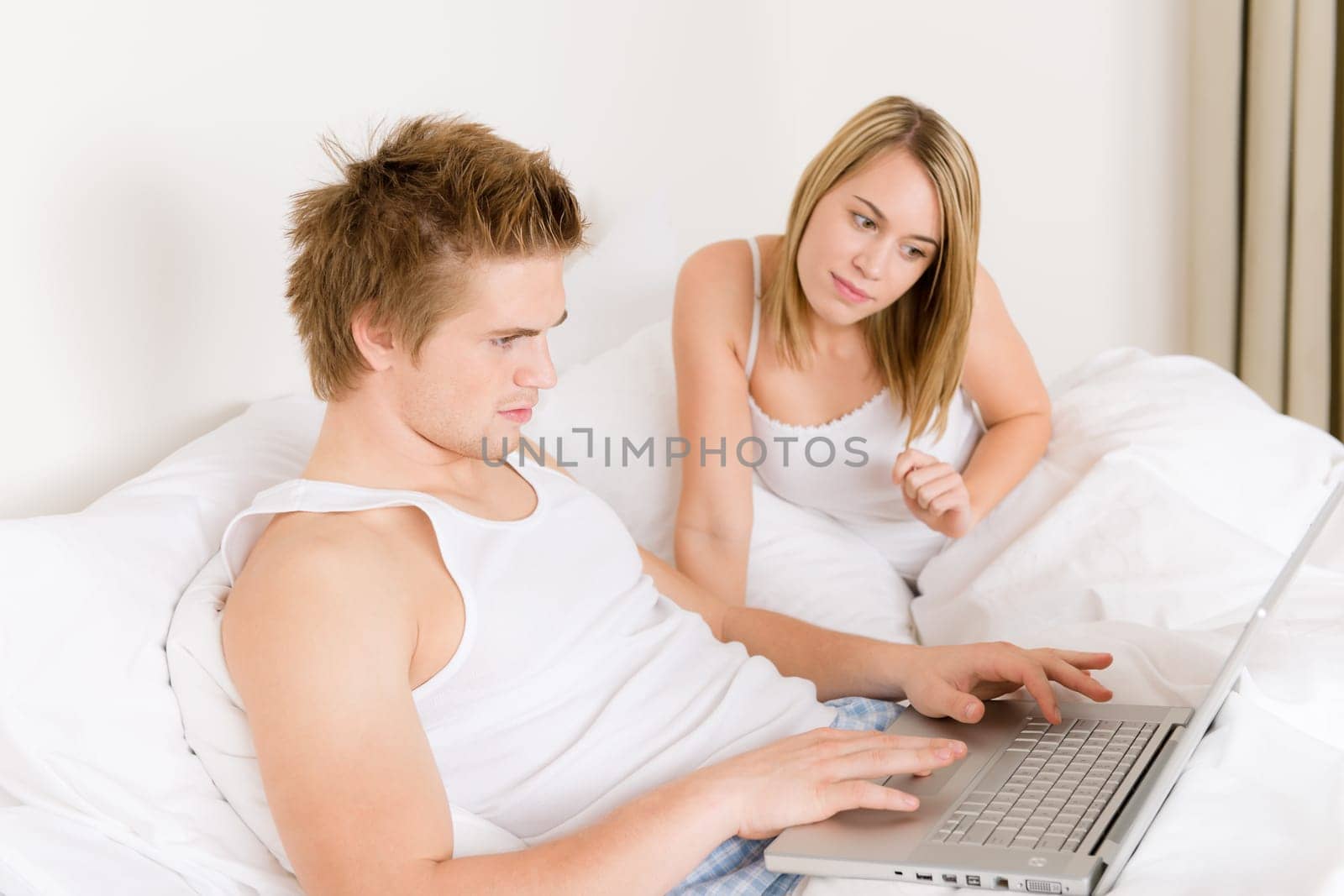 Bedroom - young couple with laptop and book