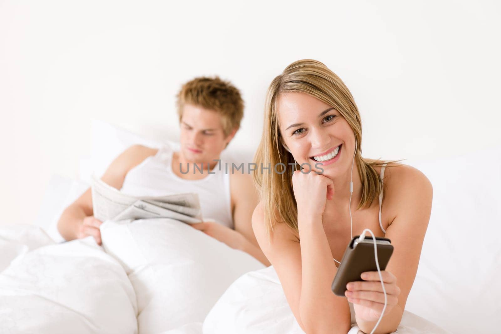 Young couple relax in bed listen to music