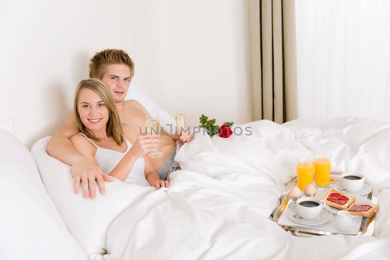 Luxury hotel honeymoon breakfast - couple in bed