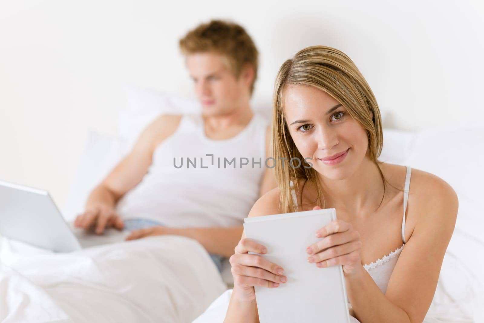 Bedroom - young couple with laptop and book