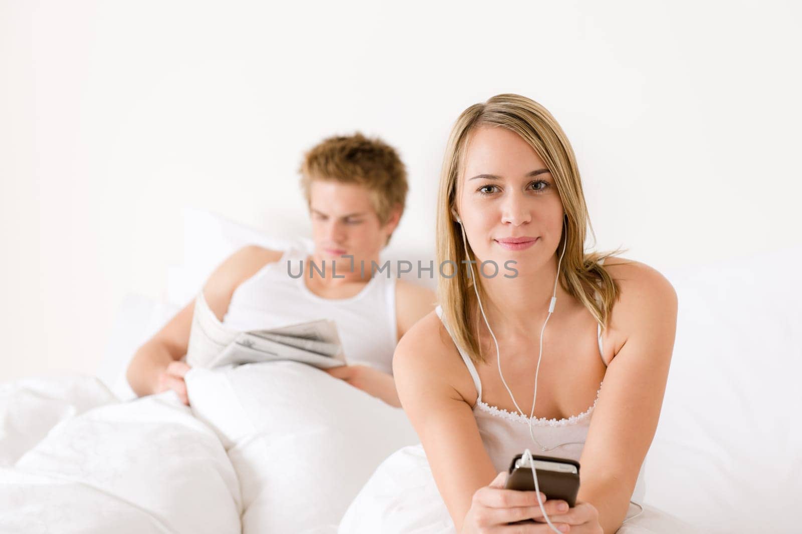 Young couple relax in bed listen to music