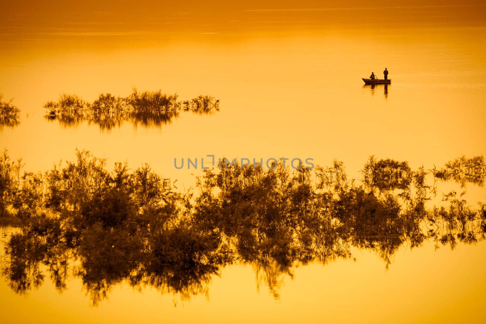 Fishing boat on lake with orange light