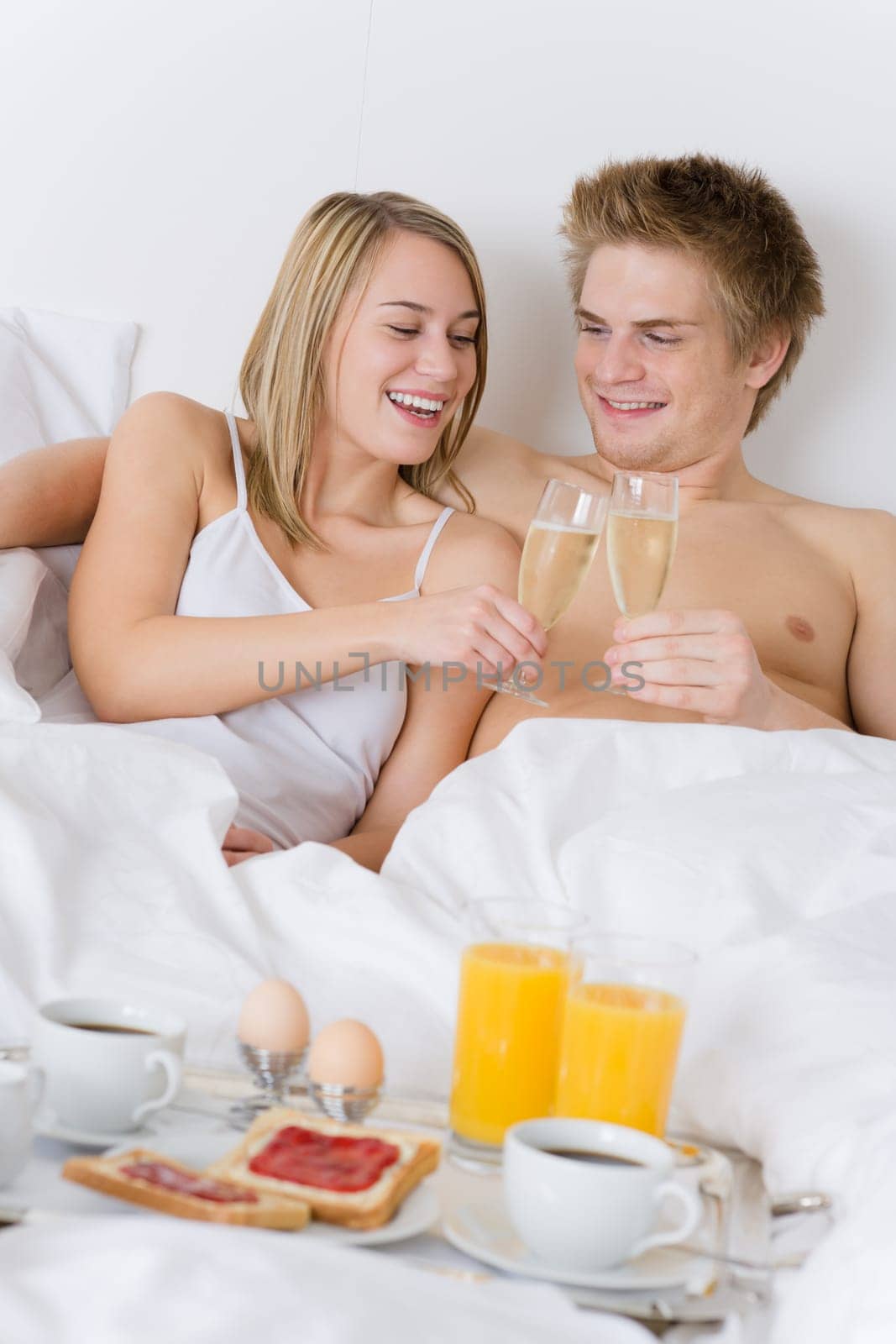 Luxury hotel honeymoon breakfast - couple in bed