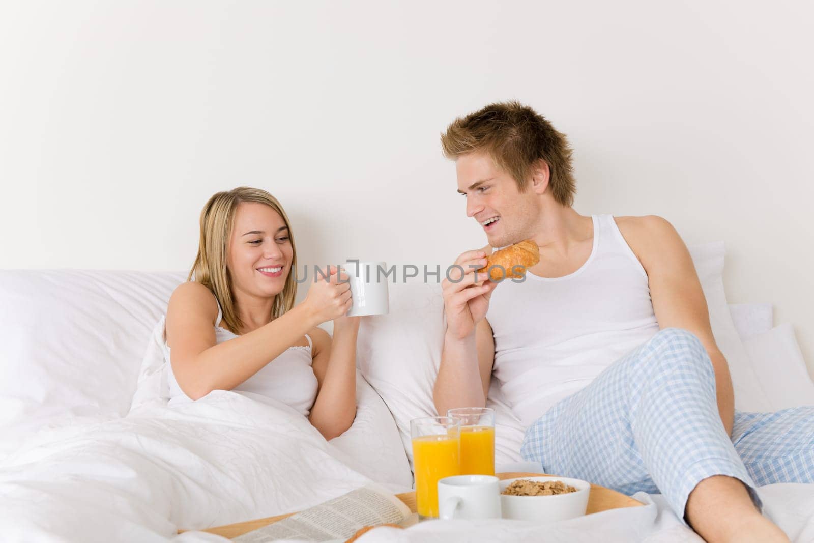 Luxury hotel honeymoon breakfast - couple in bed