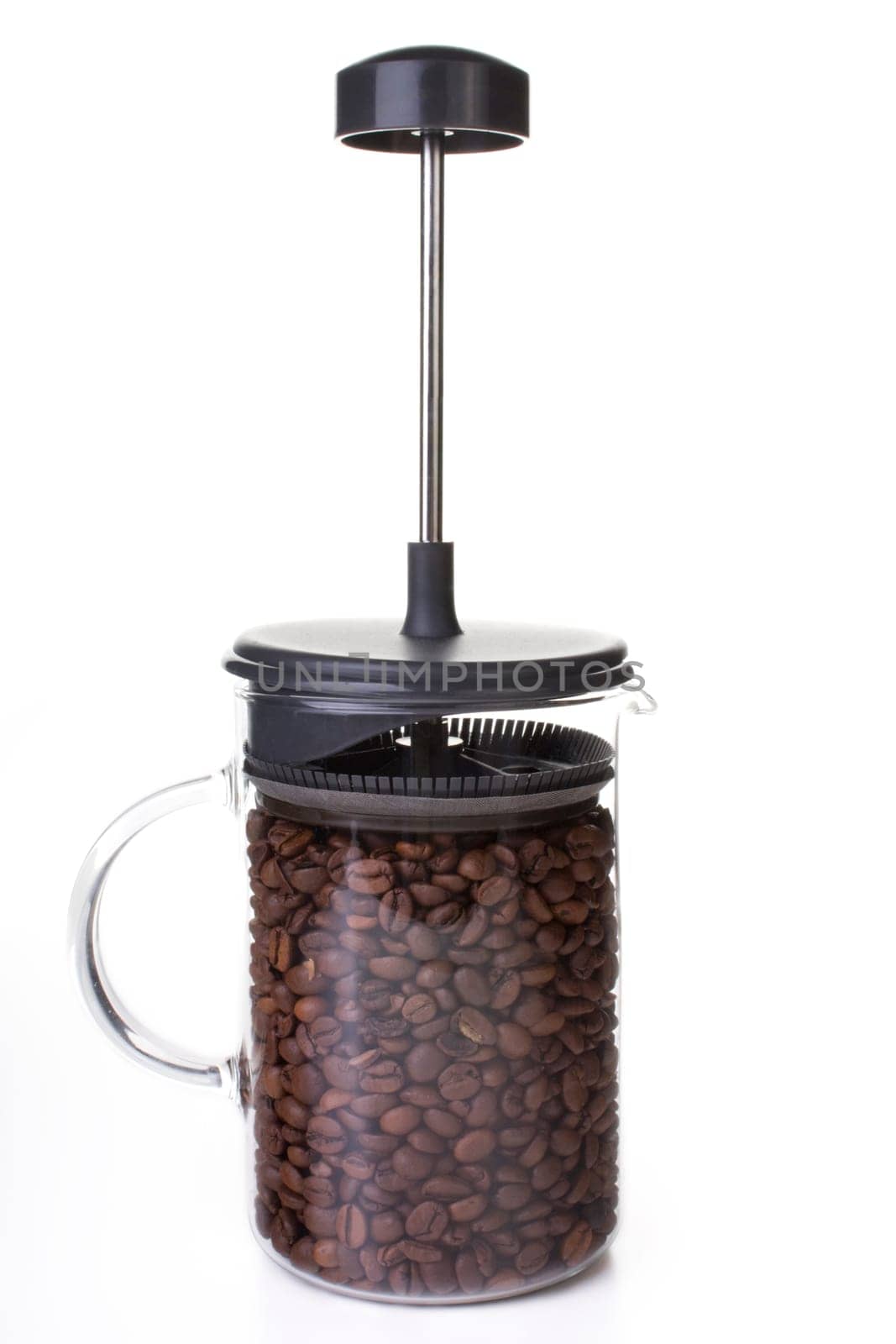 French press full of coffee beans, vertical orientation.