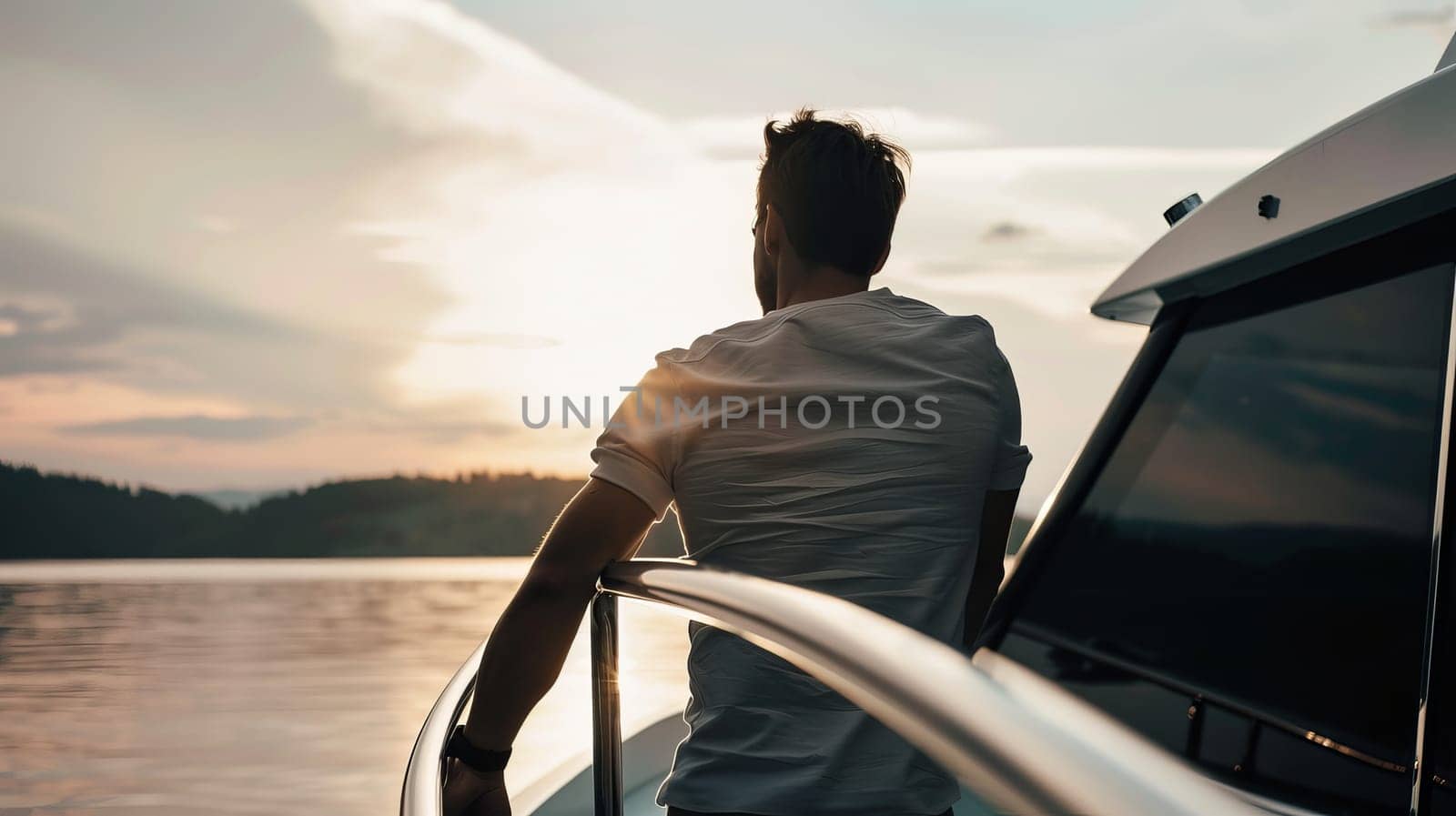 Young caucasian male enjoying sunset view from yacht deck.