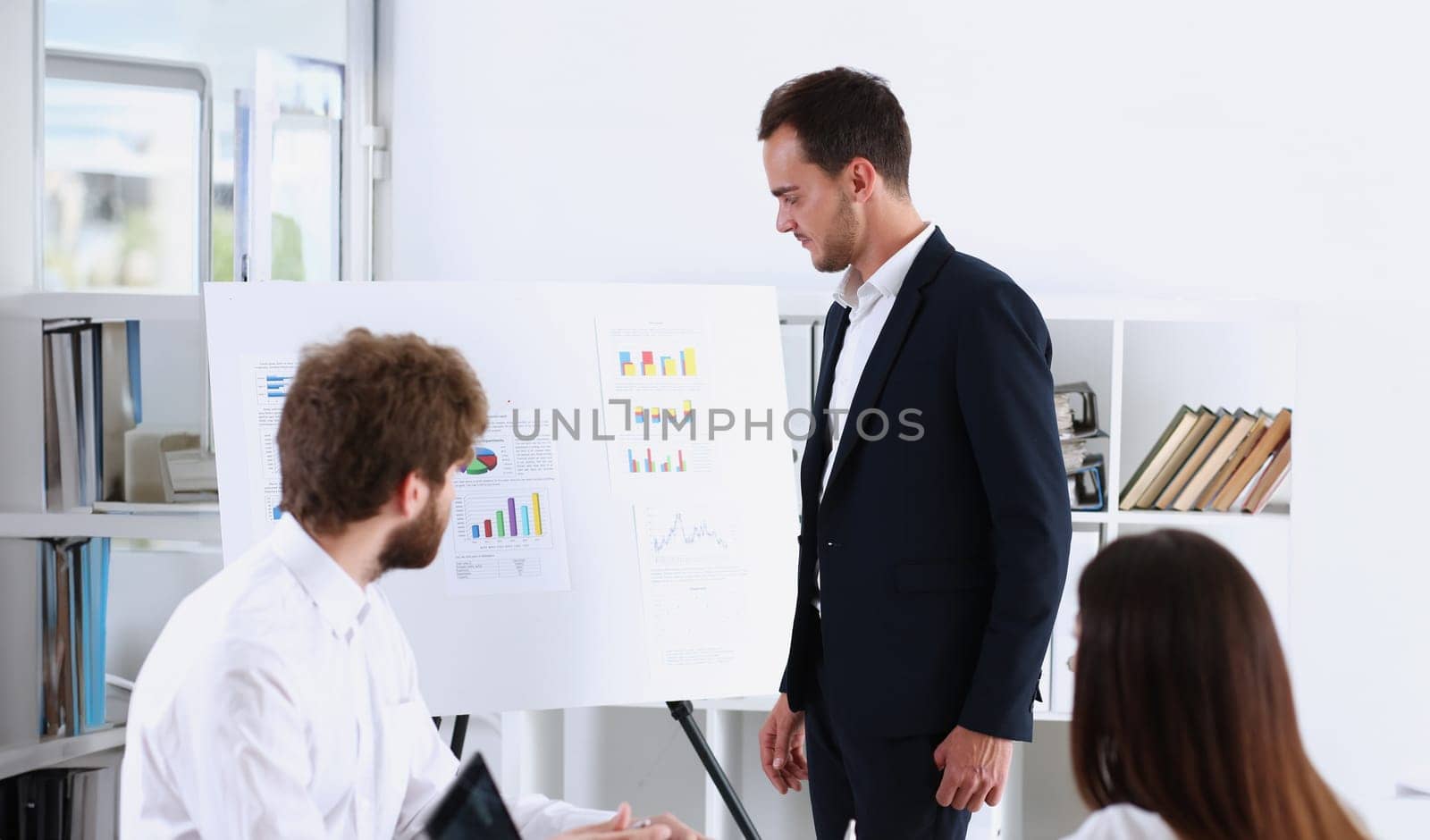 Group of people deliberate on white board by kuprevich