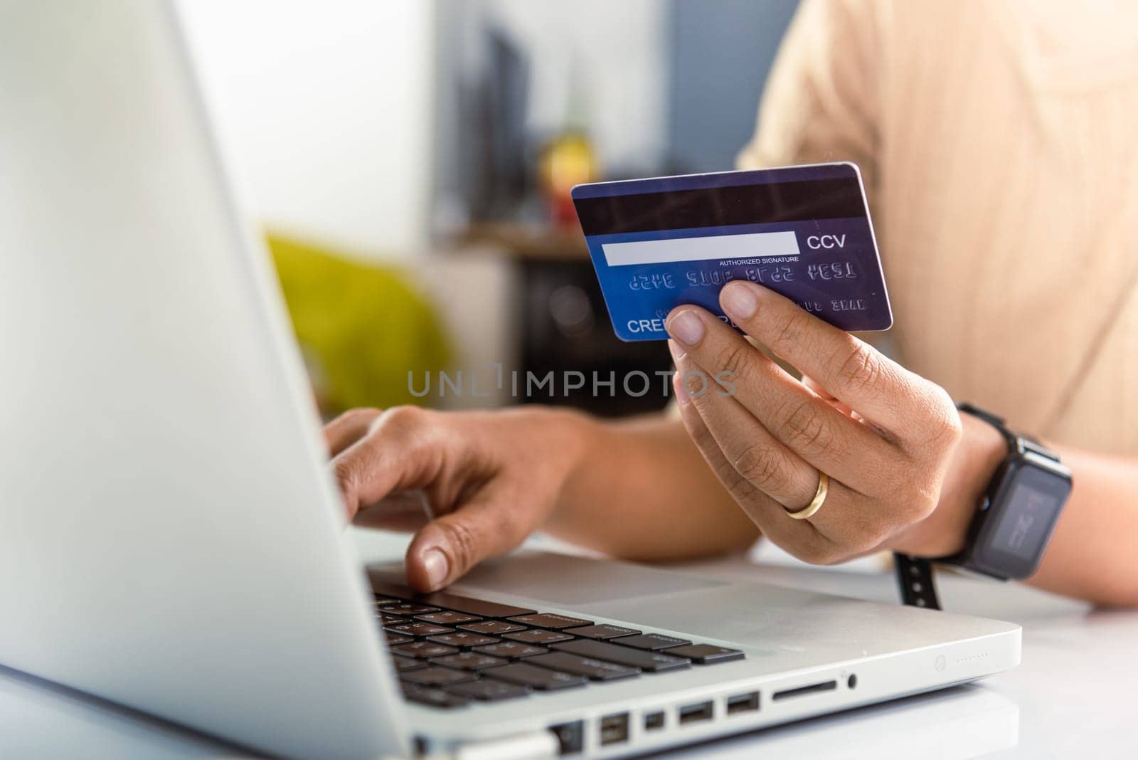 Woman hands holding credit card and using laptop with product purchase at home by Sorapop