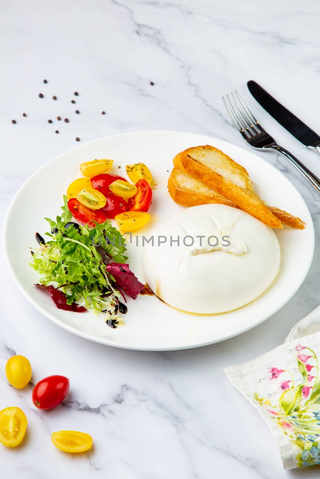 mozzarella with spinach, cherry tomatoes, wild berries and bread in a round plate side veiw by tewolf