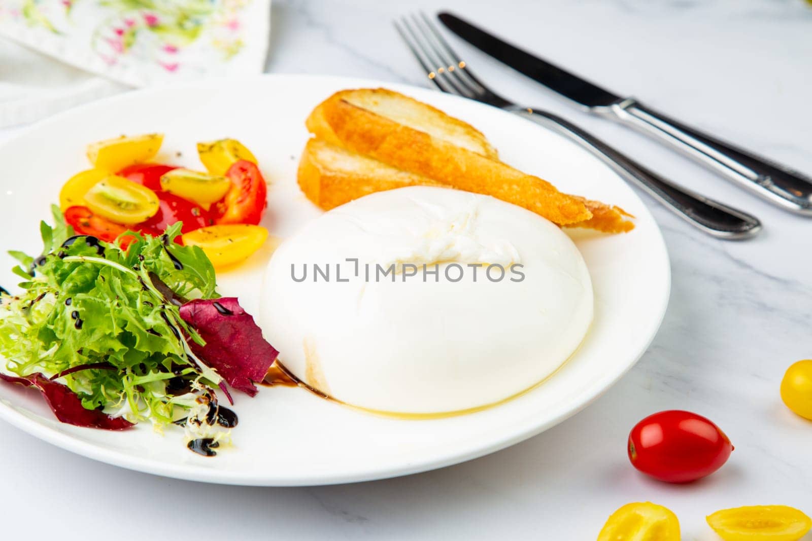 mozzarella with spinach, cherry tomatoes, wild berries and bread in a round plate side veiw by tewolf