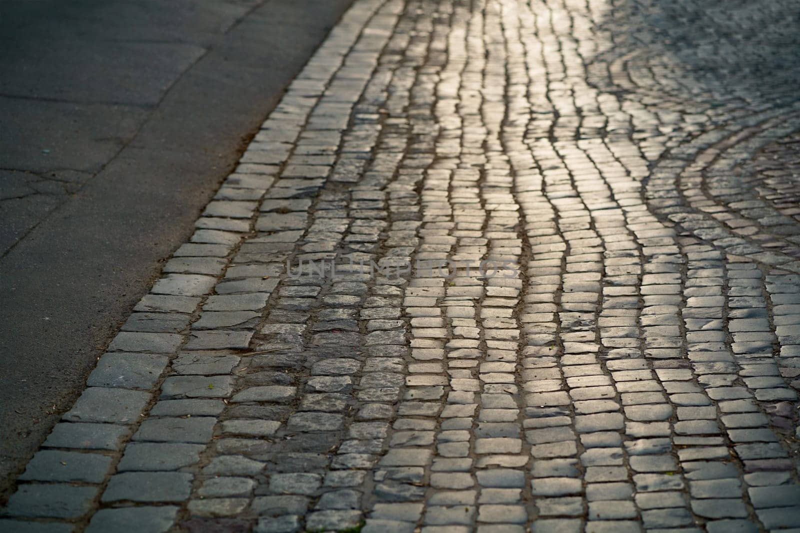 Stone pavement in perspective. Artistic texture and background. Element of the old street of the city of Lviv in Ukraine. Outdoor street design of the territory of natural stone.