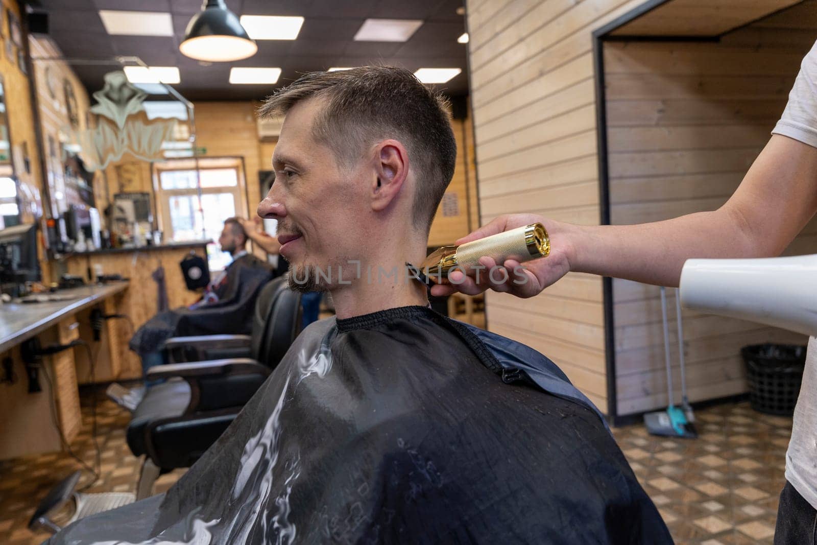 a professional hairdresser cuts a man's hair. visit to the barber shop. hair cutting for the client. creating a hairstyle in a beauty salon. Men's haircut in a barbershop.