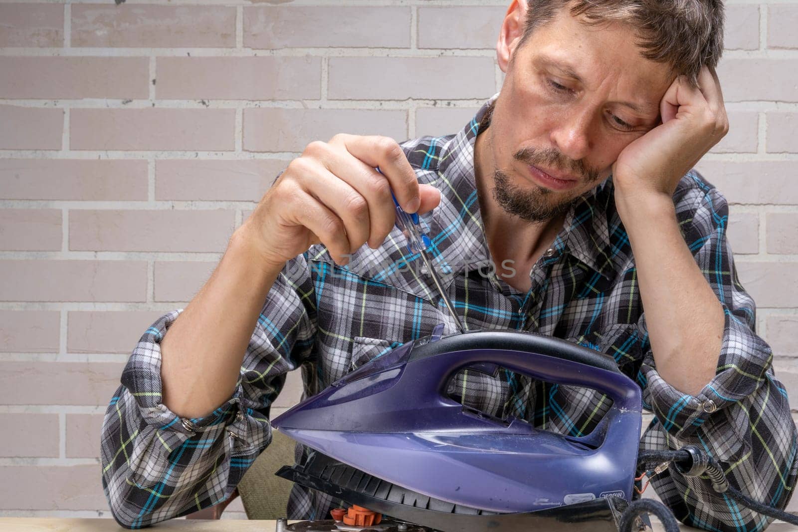 husband or the head of the family is trying to repair broken steam iron at home by audiznam2609