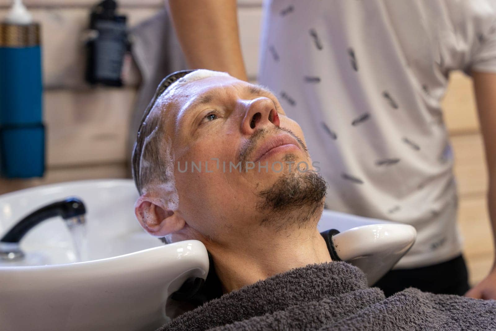 man washes his hair while visiting a hairdresser by audiznam2609