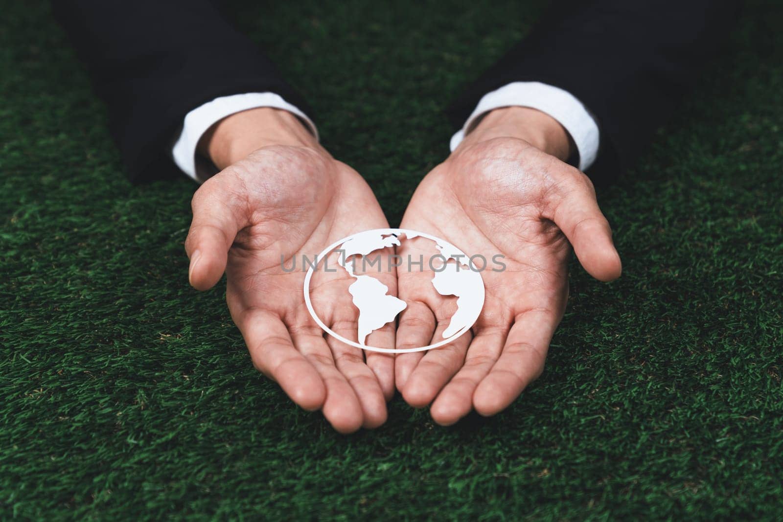 Businessman holding Earth planet icon symbolize eco-friendly business commitment to environmental protection and zero carbon emission. Earth World Day concept to promote eco awareness. Gyre